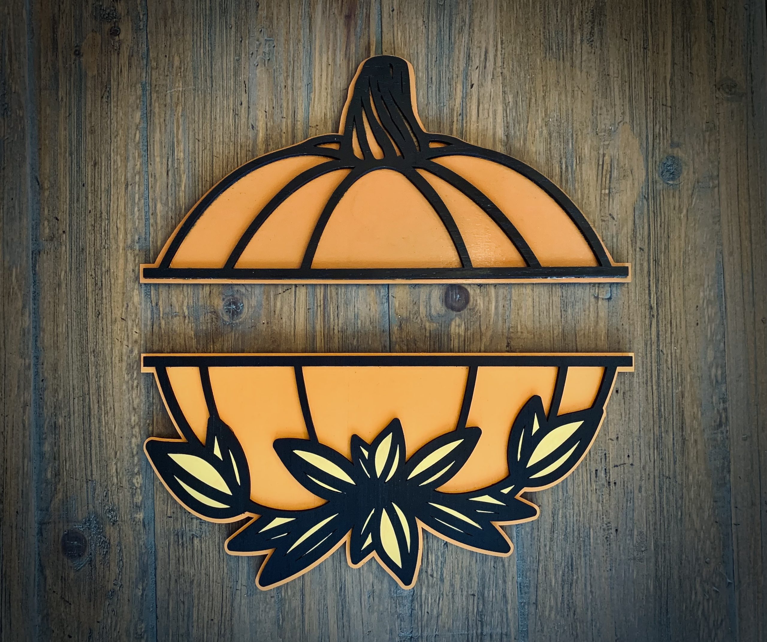 Interchangeable EverWreath autumn plate set with an orange pumpkin and layered fall leaves on a wood background