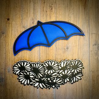 Interchangeable EverWreath spring plate set with a blue umbrella and white floral pieces on a wood background