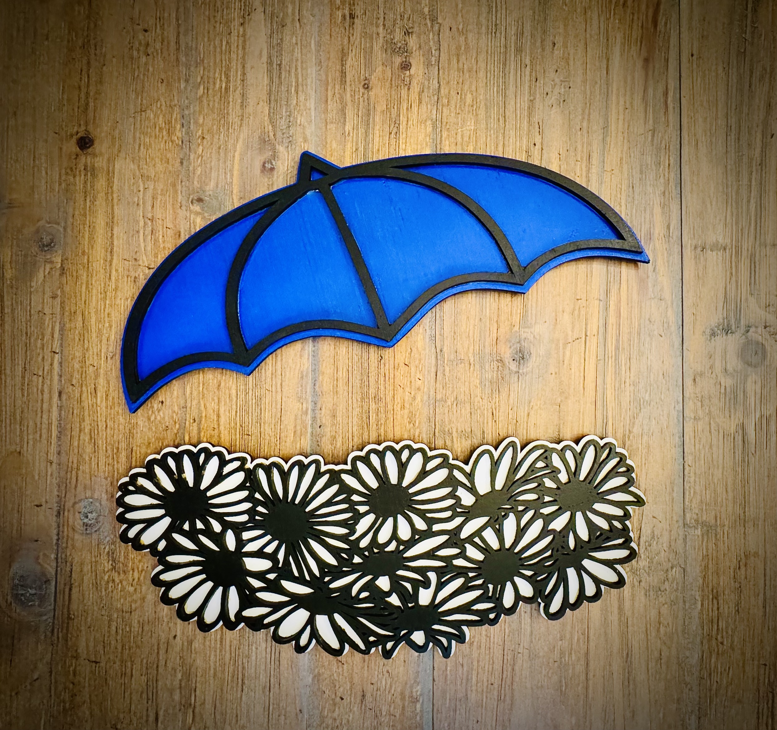 Interchangeable EverWreath spring plate set with a blue umbrella and white floral pieces on a wood background