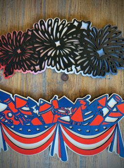 Interchangeable EverWreath fireworks plate set with red, white, and blue bunting, rockets, and layered fireworks on a wood background