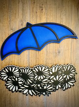 Interchangeable EverWreath spring plate set with a blue umbrella and white floral pieces on a wood background