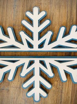 Interchangeable EverWreath winter plate set with a layered white snowflake design on a wood background